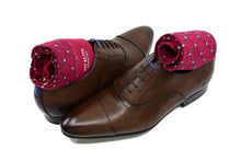 Men's patterned dress socks, red with grey polka dots, inside brown dress shoes